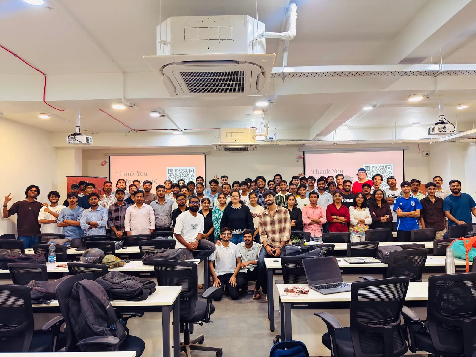 Workshop participants gathered for a group photo at the front of a lab classroom, under two Thank You slides