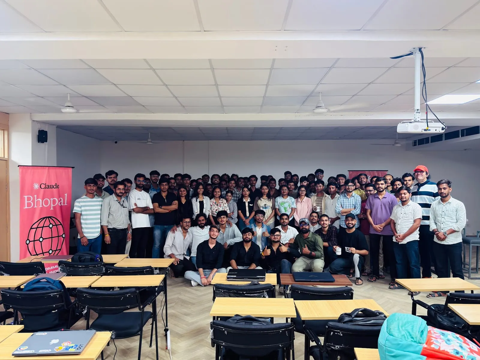 Claude Code Workshop participants posing at the front of the classroom, with the Claude Bhopal banner on the left