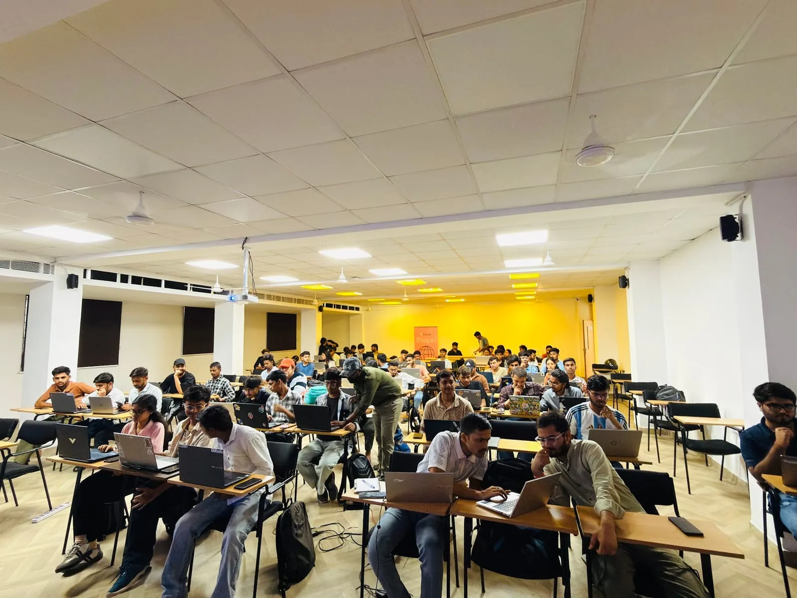 A full classroom of builders working on laptops, seen from the front corner