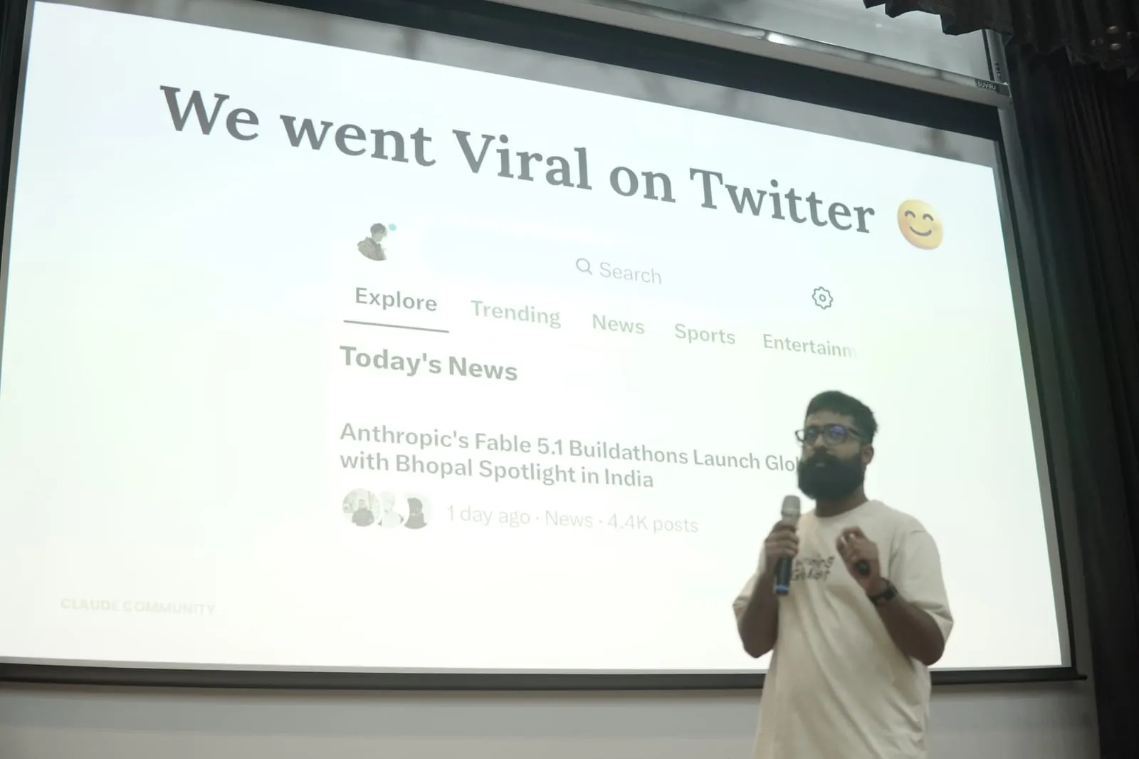 A speaker on stage beside a slide headed We went Viral on Twitter, showing a news item on Anthropic’s Fable 5.1 Buildathons with a Bhopal spotlight
