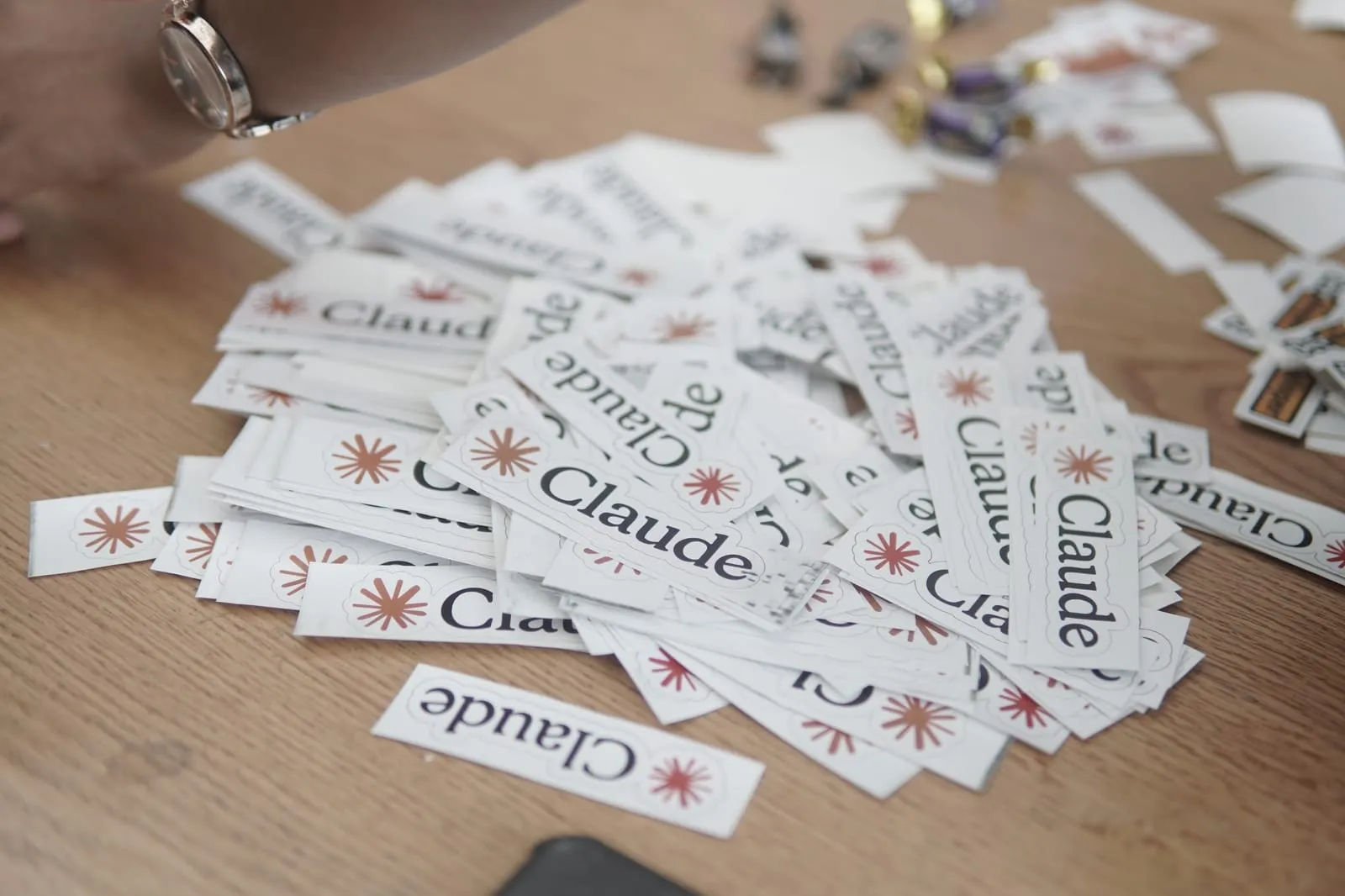 A pile of Claude stickers on a table