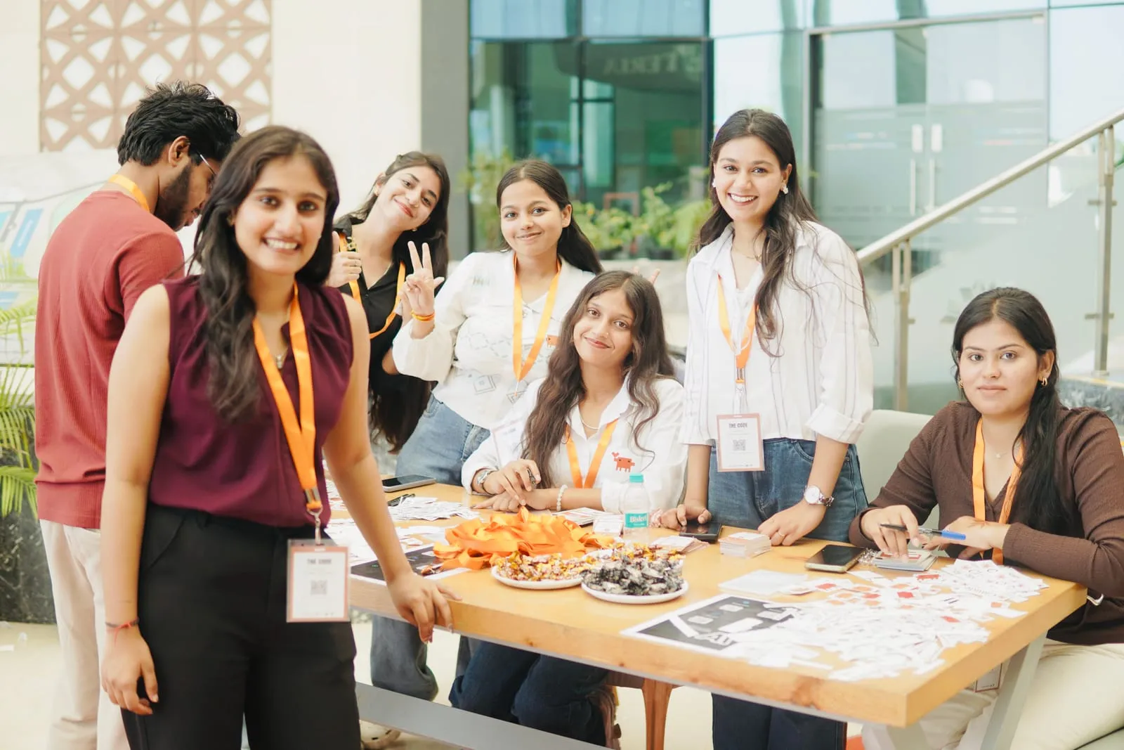 Volunteers in orange lanyards smiling at the registration desk