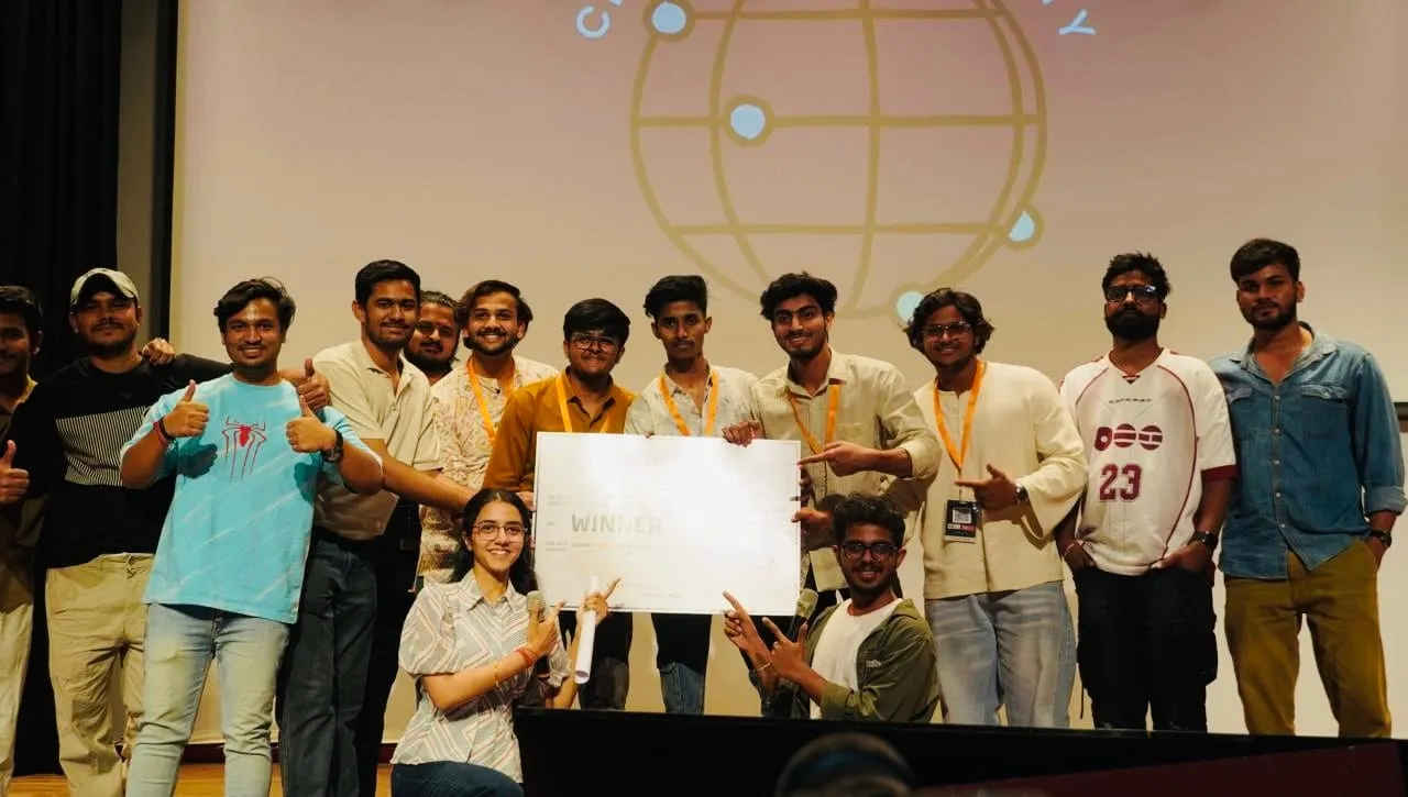 Participants on stage around a Winner cheque, giving a thumbs up
